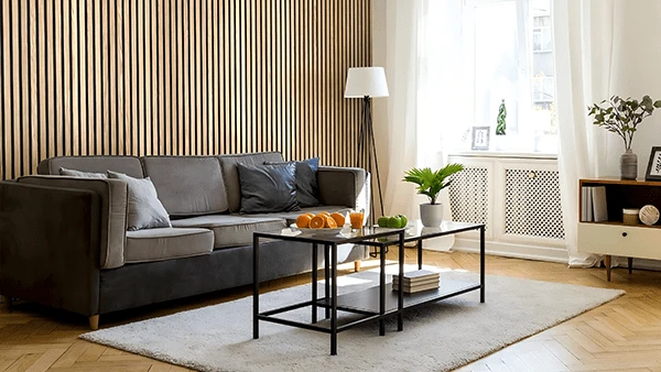 Instale paneles de pared acústicos de color madera detrás del sofá en la sala de estar