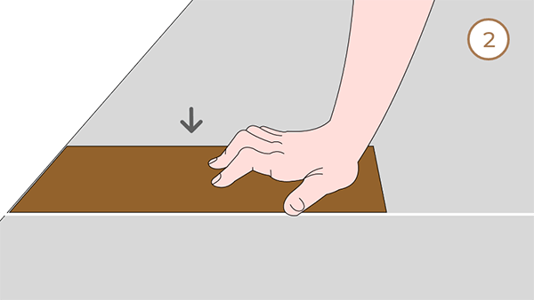 Install a piece of flooring along the marked line using one hand.