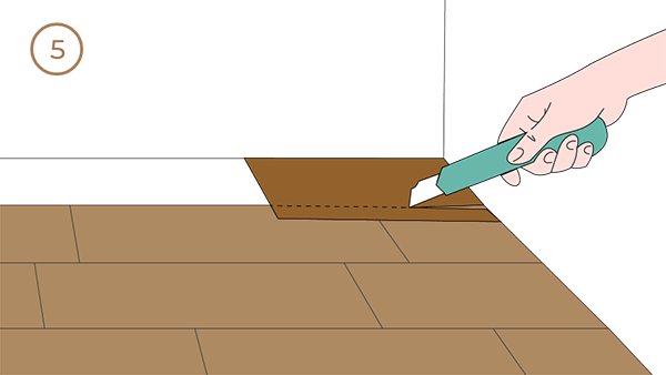 Hands are cutting the boards according to the width of the remaining space on the wall.