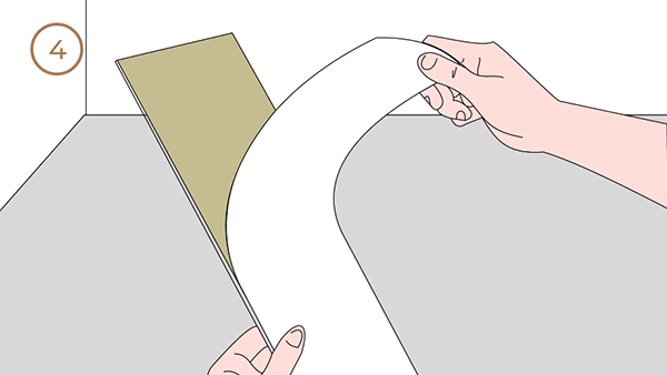 Worker peeling off the backing paper of the flooring.