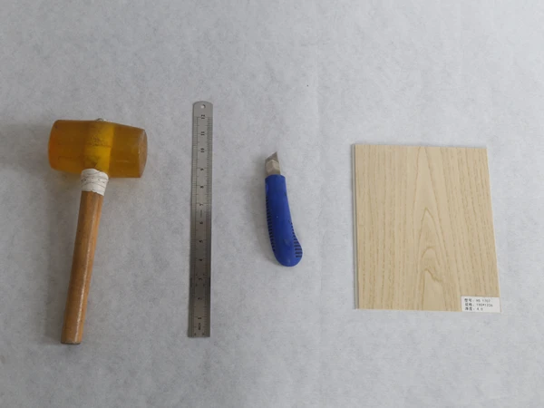 The tools needed to cut SPC flooring are placed on a white paper.