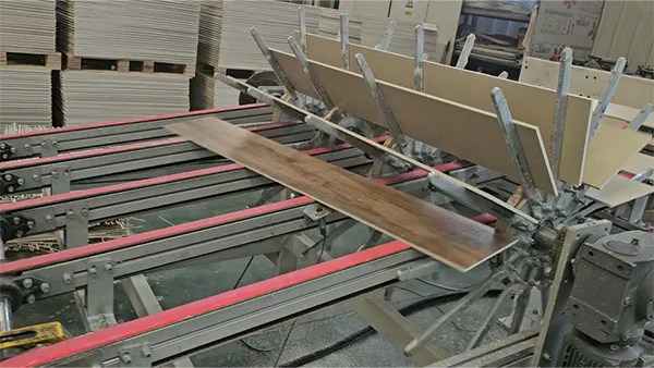 La máquina está cortando tableros SPC lateralmente.