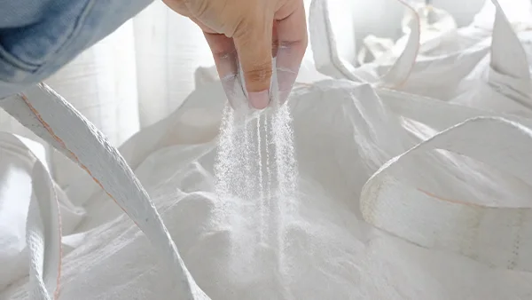 A person is inspecting the raw materials of SPC flooring by hand.