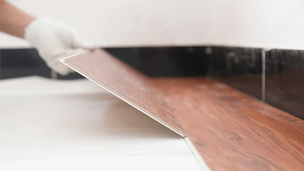 Los trabajadores están entrelazando e instalando pisos SPC en una capa base plana.