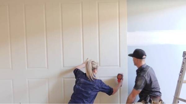 اثنين من العمال يقومون بتركيب لوحات الحائط.